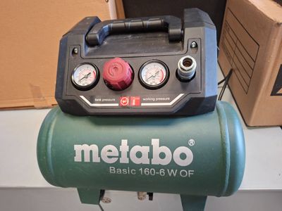 a green air compressor sitting on top of a table