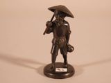 a bronze statue of a man with a hat and a cane