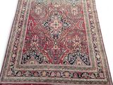 a red and blue rug with a medallion design on it