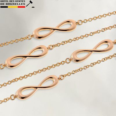 un gros plan sur trois chaînes en or ornées d'un symbole de l'infini