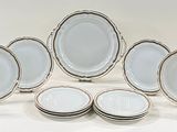 twelve pieces of white and silver dinner plates with silver rims
