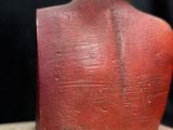 a red statue of a man with a hat on