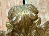 a gold statue of a flower with leaves on it