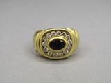 a close up of a gold ring with a blue stone