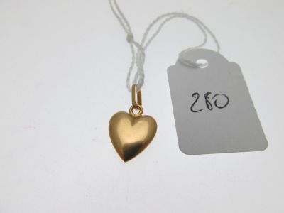 un pendentif en forme de cœur en or auquel est attachée une étiquette de prix