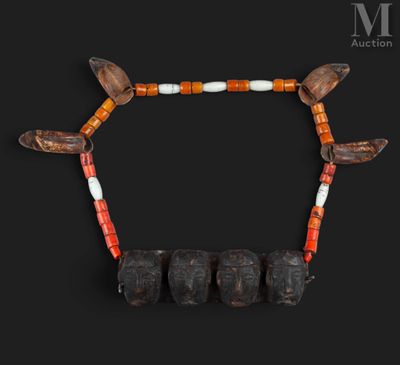 un gros plan sur un collier composé de perles en bois, avec des perles orange et blanches