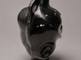 une petite statue d'éléphant noir posée sur une surface blanche
