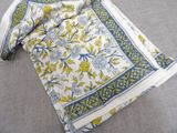 an image of a white and blue table cloth with yellow flowers on it