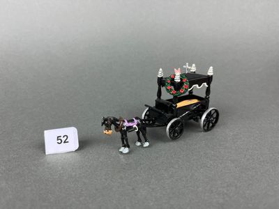 a small toy horse pulling a carriage with a sign next to it