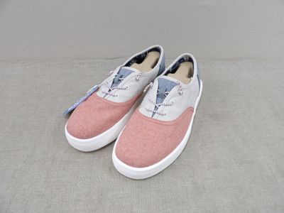 des Vans roses et blanches à enfiler, ornées d'un nœud bleu sur le côté