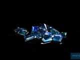blue glass shards on a black surface with a black background