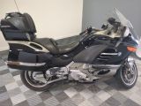 a black motorcycle parked on a checkered tile floor