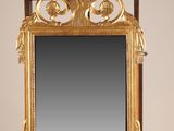 un miroir ancien en bois posé sur un pied, avec un miroir au centre