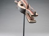 sculpture of a dragon ' s head on a stand with a gray background