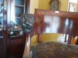 a chair that is sitting in a room with a clock on the wall