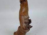 un oiseau en bois perché sur une souche d'arbre