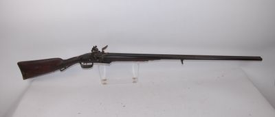 a rifle with a wooden barrel on a white surface