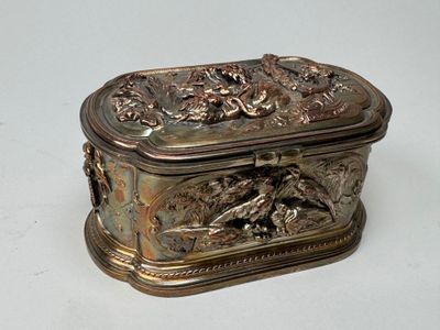 a silver box with a design on it on a white surface