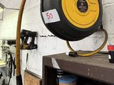 a hose that is attached to a shelf in a garage