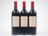 trois bouteilles de vin rouge posées l'une à côté de l'autre sur une surface blanche