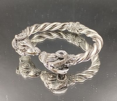 deux bracelets en argent sur une surface noire avec un fond argenté