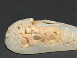a white jade carving of a dragon and other animals on a rock