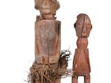 two wooden figurines of a man and a woman on a white background