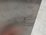 a person holding a knife in their hand near a piece of metal