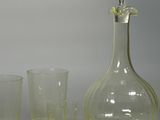 three glasses and a decanter sitting on a table