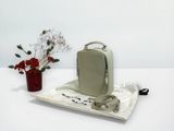 a small bag sitting on a table next to a vase