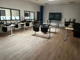 des tables et des chaises dans une pièce équipée d'une télévision à écran plat
