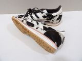 pair of black and white cow print shoes on a white surface