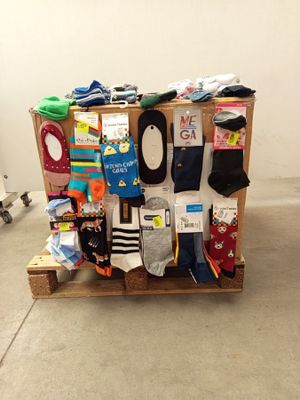 de nombreuses paires de chaussettes empilées sur une palette dans une pièce
