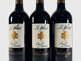 trois bouteilles de vin rouge posées l'une à côté de l'autre sur une surface blanche