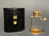 a small bottle of perfume next to a black case