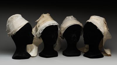 trois têtes de mannequins sont alignées les unes à côté des autres, coiffées de chapeaux