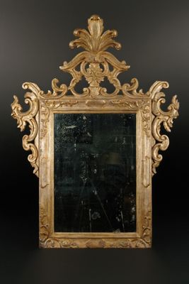 une image représentant un miroir à cadre doré accroché à un mur noir