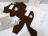 a baby ' s clothing on a table next to a box of clothes