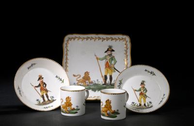 un ensemble d'assiettes et de tasses ornées d'une image représentant un homme et un chien