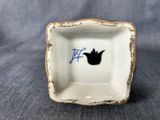 an image of a small white plate with a black bird on it