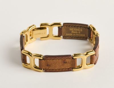 une photo d'un bracelet doré et marron muni d'une étiquette