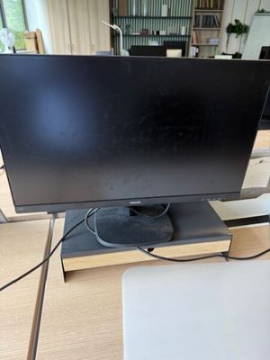 un écran d'ordinateur posé sur un bureau en bois