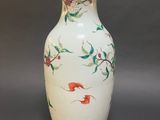 a white vase with a floral design on it