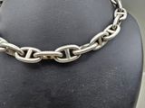 a close up of a silver chain necklace on a mannequin