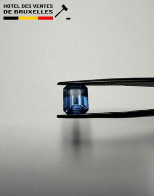 someone is holding a pair of pliers with a blue diamond in it