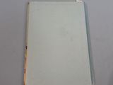 an old book sitting on top of a table next to a glass