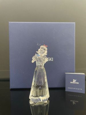La figurine en verre est posée sur la table, à côté de la boîte.