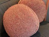 pair of orange herringle pillows sitting on a grey couch