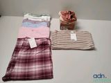trois paires de pyjamas pour homme posées sur une table à côté d'un panier