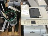 a pile of computer equipment on a pallet in a warehouse